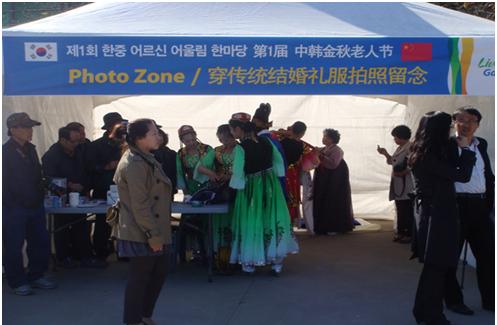 第一届中韩金秋老人节举办，中国游客在体验韩国传统结婚礼服。