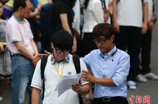 资料图：当地时间2014年6月25日，韩国“世越号”沉船事故中生还的京畿道安山市檀园高中2年级部分学生在事发后时隔71天重返校园。部分遇难学生的家长当天到学校迎接生还学生，学生和家长互相安慰和鼓励。