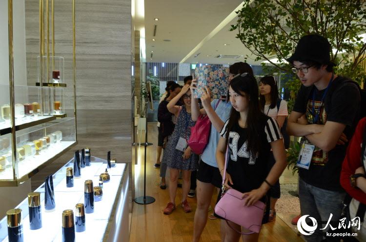 中韩青年代表在参观婵真化妆品公司的产品。