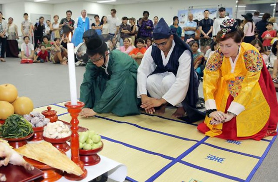 图为身穿韩服的外籍居民正在学习中秋节传统礼仪