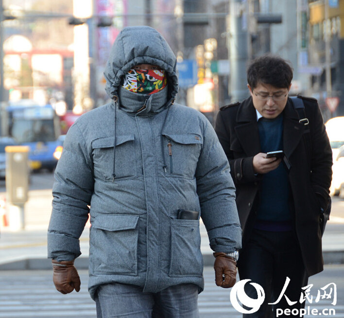 首尔街头的行人"全副武装,抵御寒流(摄影:黄海燕)