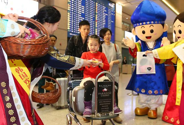韩国旅游发展局的工作人员向到达仁川机场的中国游客发放纪念品(网页截图)
