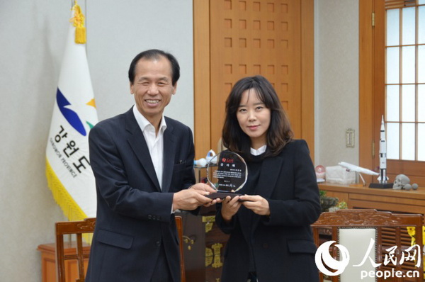 人民网韩国公司负责人周玉波向韩国江原道知事授予感谢牌