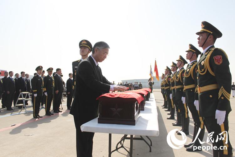 中国驻韩国大使为烈士遗骸覆盖国旗（黄海燕 张悦 裴埈基摄）