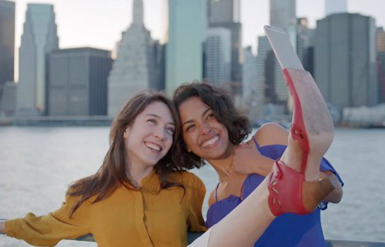 视频中，两位女模特笑意融融地将手机插到鞋头，不停变换姿势进行自拍。（图片来自Miz Mooz公司发布的产品视频截图）