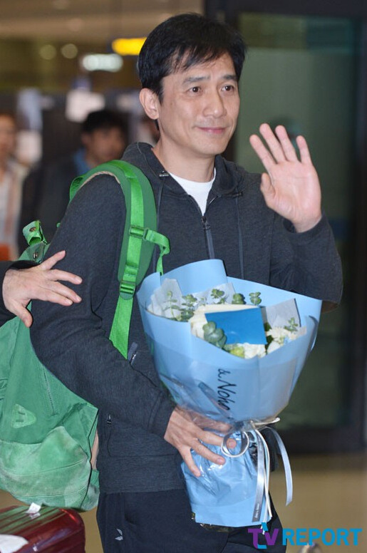 梁朝伟现身韩国机场受追捧 收到鲜花露笑容【组图】