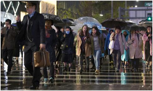 上班早高峰,首尔市民在雨中疾驰(图片来源:韩联社)