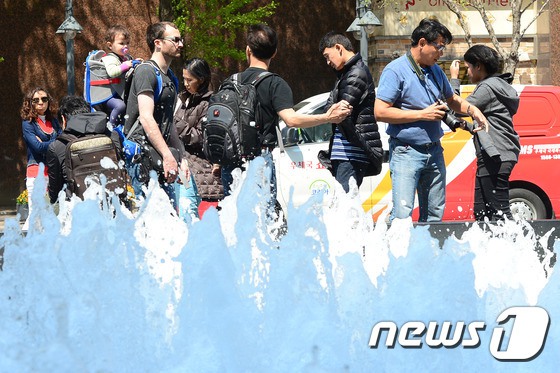 【组图】“热浪”突袭韩国 民众短衣短袖出行