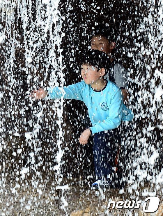 【组图】“热浪”突袭韩国 民众短衣短袖出行