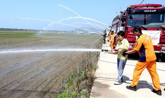 国总统朴槿惠访问韩干旱受灾区 拿消防水带向