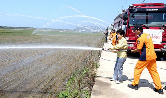 国总统朴槿惠访问韩干旱受灾区 拿消防水带向