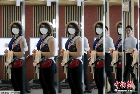 资料图：当地时间2015年6月8日，韩国首尔，游客戴口罩防止感染中东呼吸综合征(MERS)。