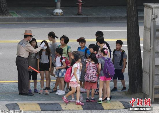 当地时间2015年6月17日，韩国首尔，小学生在排队量体温。