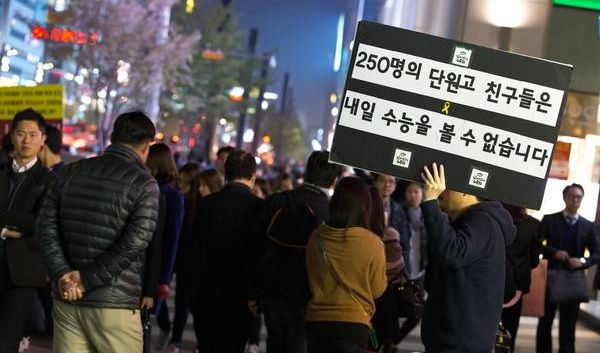 韩国高考前一天，遇难学生家属在江南站举着“檀园高中的250个孩子明天不能参加高考了”的牌子。