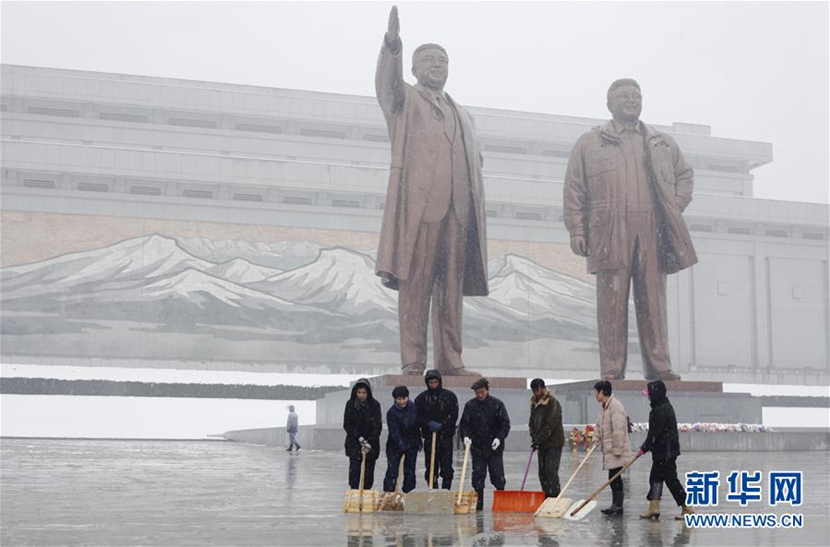 11月25日，在朝鲜首都平壤，民众在万寿台广场清扫冰雪。 新华社记者朱龙川摄