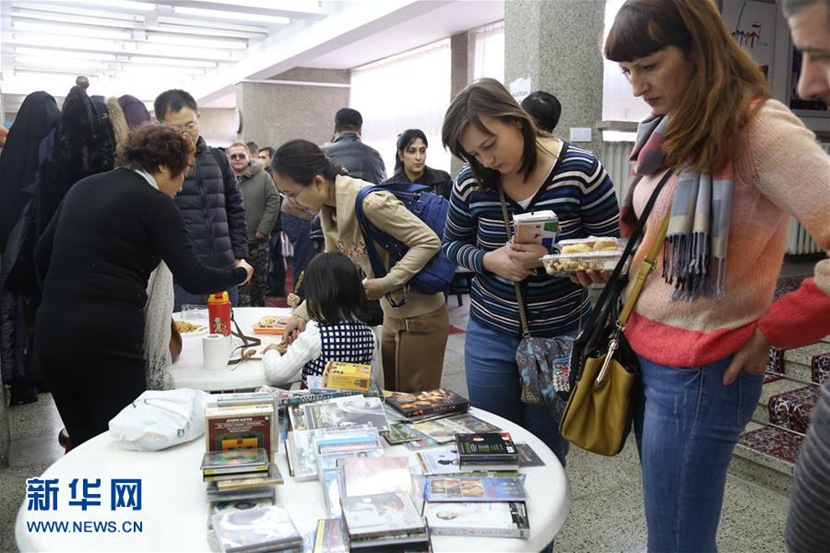  12月5日，在朝鲜平壤，参观者在义卖现场挑选影碟。 新华社记者陆睿摄