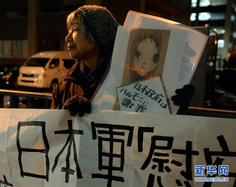 一名市民手举“日本政府向老奶奶谢罪”的标语抗议日韩“慰安妇”协议。
