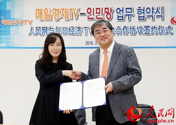 人民网韩国公司总经理周玉波（左）与韩国每日经济电视台代表理事徐廷禧（右）签署新闻互换合作协议。