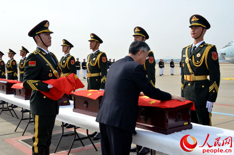 中国驻韩国大使邱国洪为中国人民志愿军烈士遗骸棺椁覆盖国旗。夏雪 摄