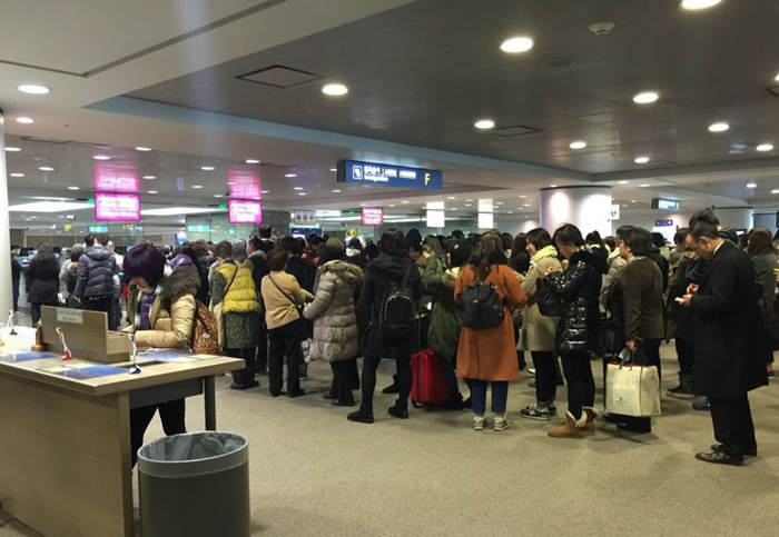 在仁川机场等候入境边检的外国人
