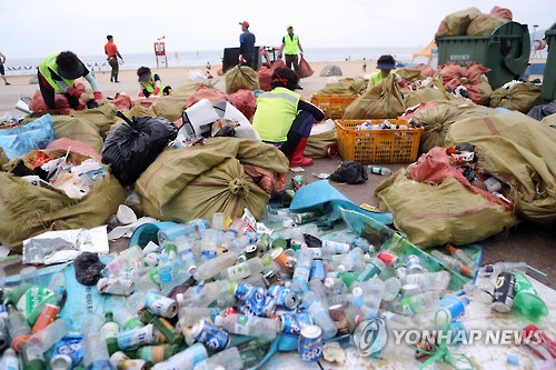 海云台环卫工人正在清理海水浴场垃圾（图片来源：Yonhapnews)
