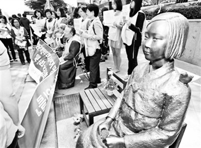 图为韩民众在日驻韩大使馆前的慰安妇铜像旁抗议。图片来源：搜狐网 