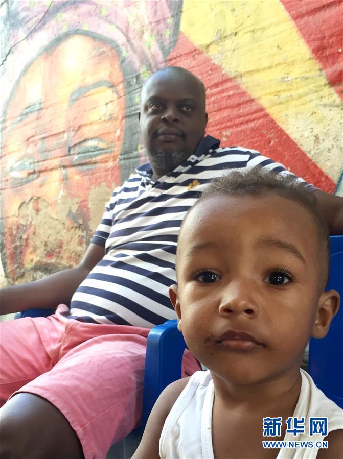 8月4日，在曼盖拉居民区，一名儿童和家人在过道休息