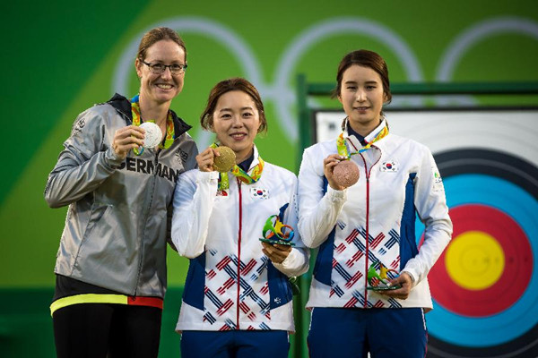 8月11日，韩国选手张惠珍（中）、德国选手翁鲁（左）与韩国选手奇甫倍在颁奖仪式上。