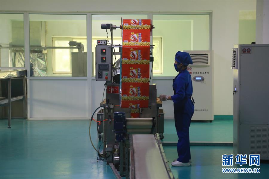 在朝鲜平壤，金杯体育人综合食品厂的工人在生产虾条。