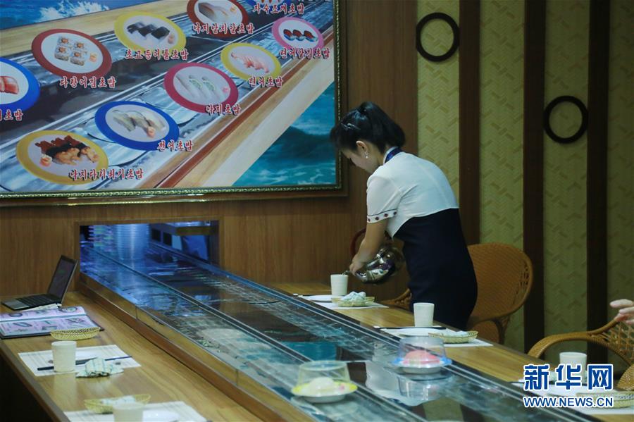 9月21日，在朝鲜平壤，餐厅服务员为客人倒茶。