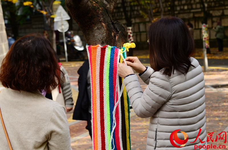 市民在為樹木編織毛線外衣。成碩攝