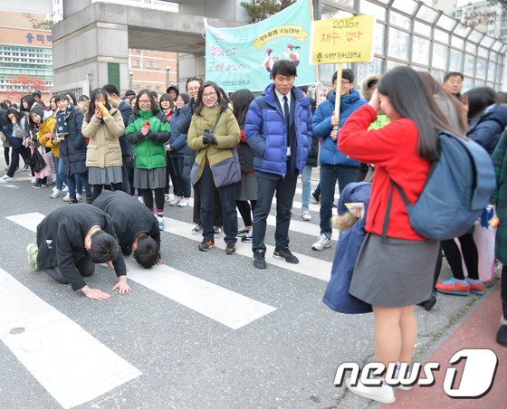 韓國大邱市某考場前，學弟們“叩拜”學姐，為其高考加油。