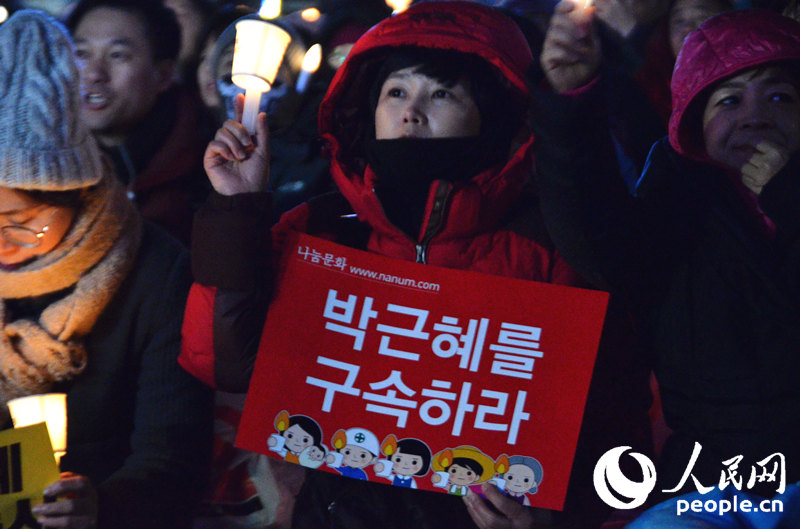 示威者手舉“逮捕朴槿惠”標語。成碩攝