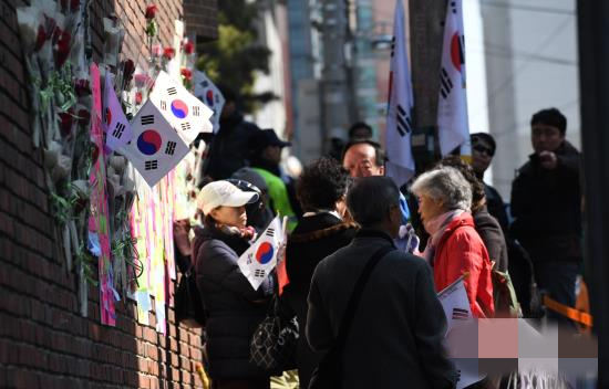 朴槿惠的支持者將鮮花和太極旗放在牆外。