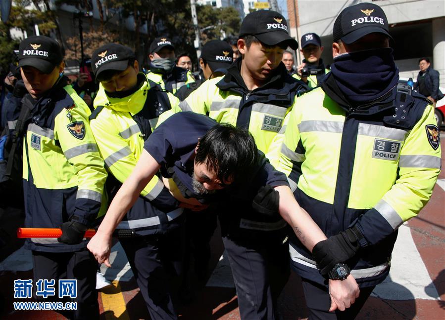 3月15日，在位於韓國首爾的朴槿惠私宅外，警察將一名攜帶可疑物品的男子帶離。