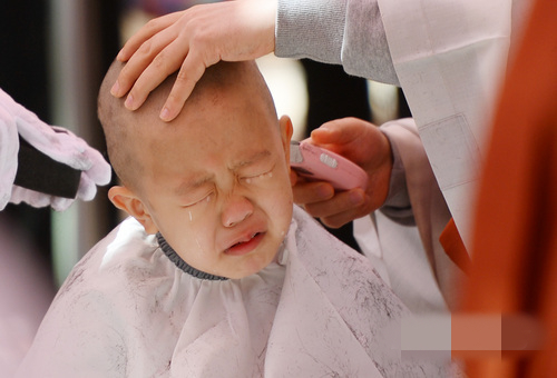 一名兒童在剃度過程中哇哇大哭。