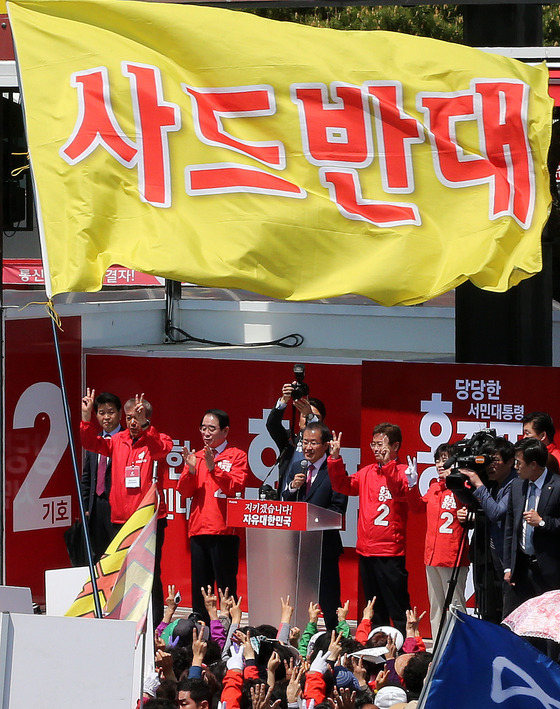 自由韓國黨總統候選人洪准杓27日前往慶尚北道金泉拉票，遇到反對部署“薩德”反導系統的民眾集會示威。集會者舉起“反對‘薩德’”的旗幟。