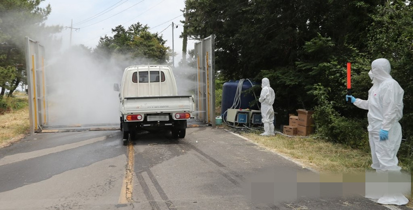 6月5日，韓國濟州，防疫人員正在對給通行車輛消毒。