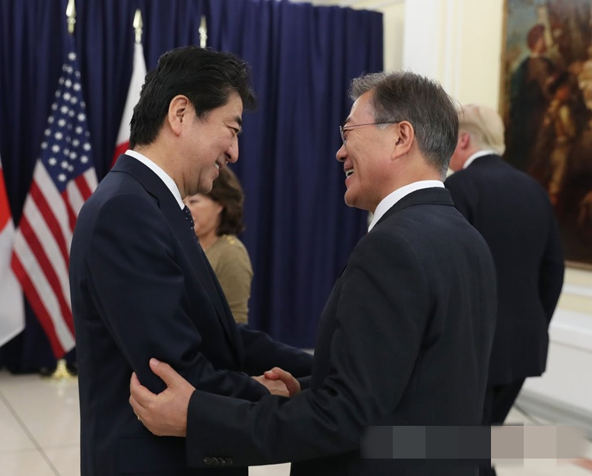 韓國總統文在寅與日本首相安倍晉三交談。當地時間7月6日，韓美日首腦晚餐會在美國駐漢堡總領事館舉行。
