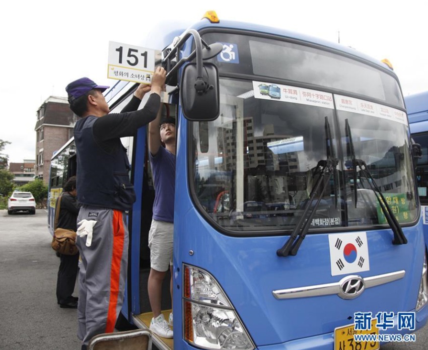 8月13日，在韓國首爾，工作人員在151路公交車上設置“慰安婦”少女像標簽。新華社記者姚琪琳攝 