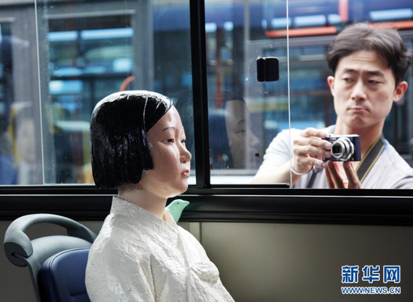 8月13日，在韓國首爾，一位記者拍攝151路公交車上的“慰安婦”少女像。新華社記者姚琪琳攝 