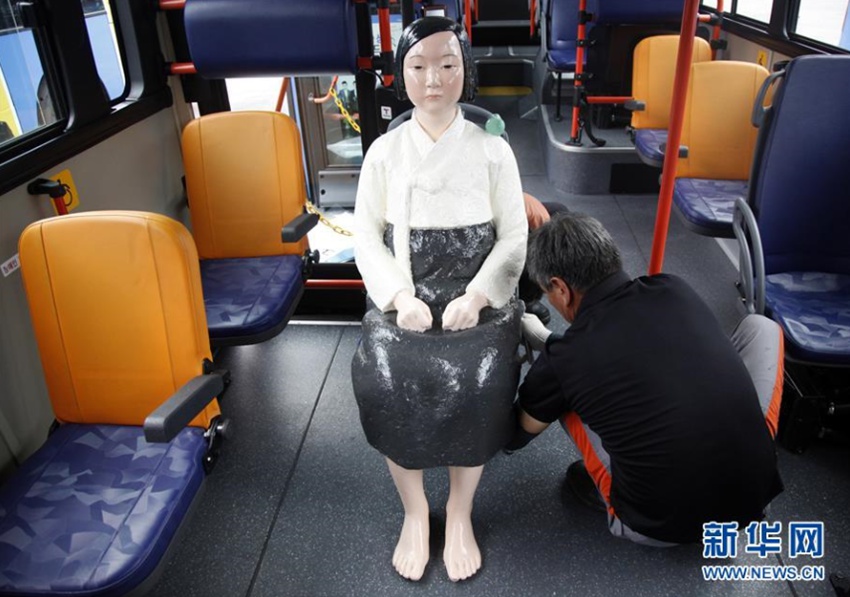 8月13日，在韓國首爾，工作人員在151路公交車上安裝“慰安婦”少女像。新華社記者姚琪琳攝 