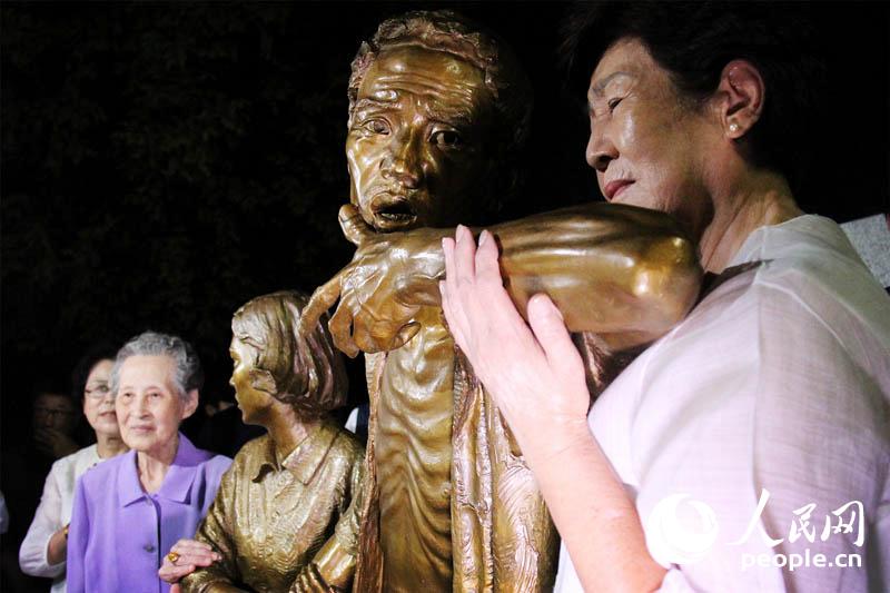 雕像“解放的預感”中表現了一對朝鮮半島父親和女兒的形象，二者均取自日本殖民統治時期強征朝鮮勞工受害者原型。圖為作品短發少女原型池英禮（左）和父親原型李蓮珩長女（右）與雕像作品一起留念。 陳尚文攝