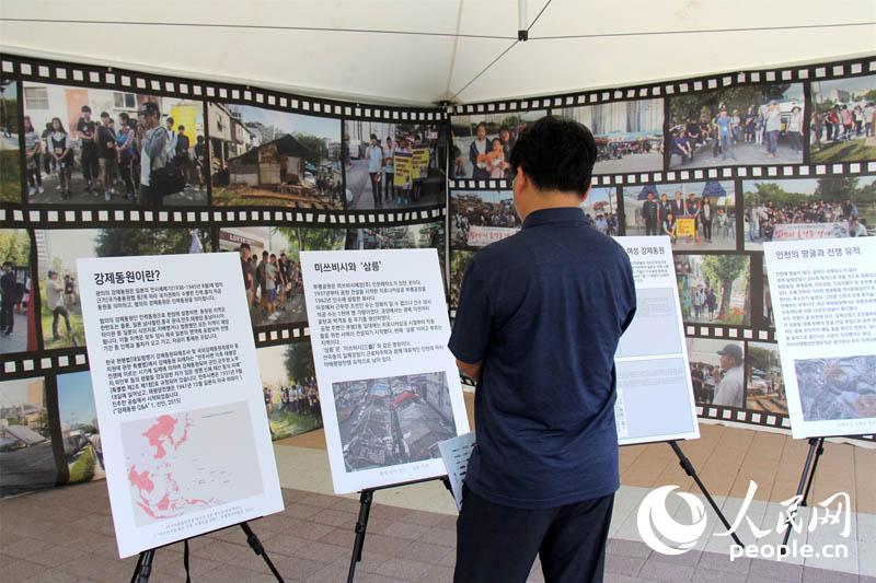 雕像“解放的預感”揭幕現場，仁川市民在觀看強征勞工歷史介紹板。 陳尚文攝