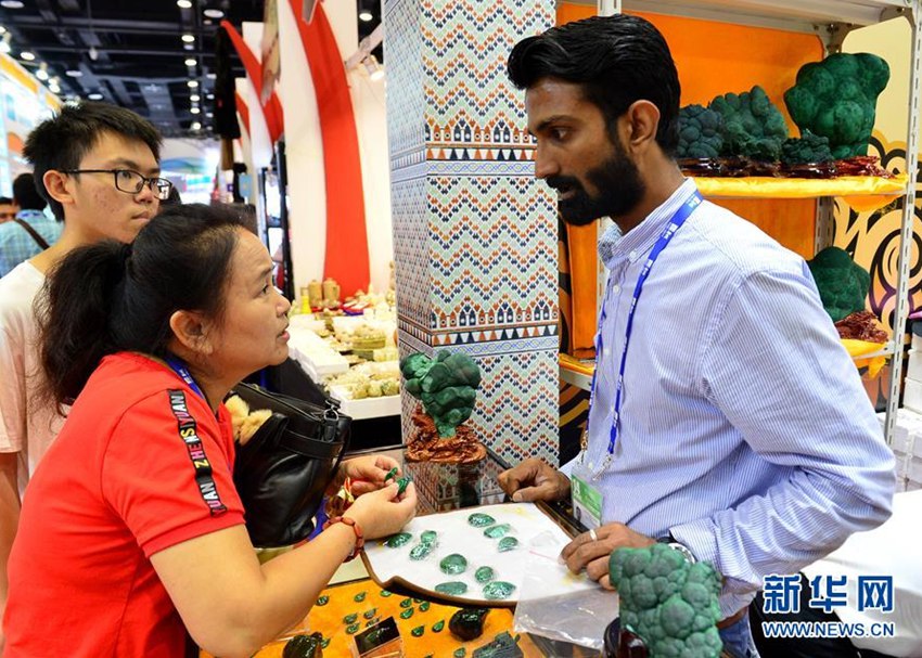 9月14日，在廣西南寧國際會展中心，來自巴基斯坦的客商（右）在向觀眾介紹寶石產品。新華社記者李絢麗攝
