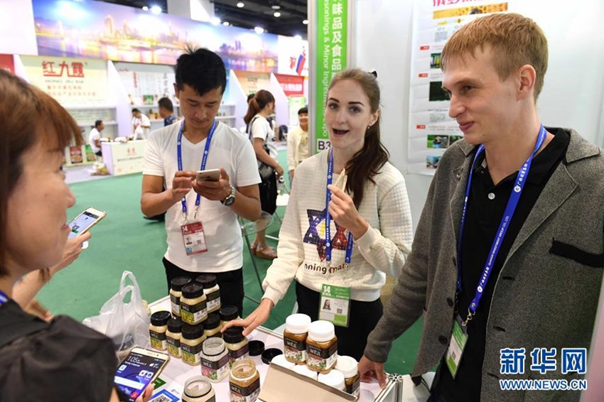 9月14日，在廣西南寧國際會展中心，俄羅斯展商在向觀眾介紹蜂蜜。新華社記者周華攝