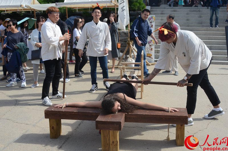 外國游客體驗韓國傳統刑罰。周軒攝