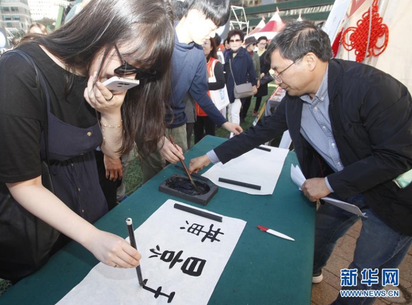 10月22日，在韓國首爾，民眾在“首爾·中國日”活動現場體驗用毛筆寫自己的名字。新華社記者 姚琪琳 攝
