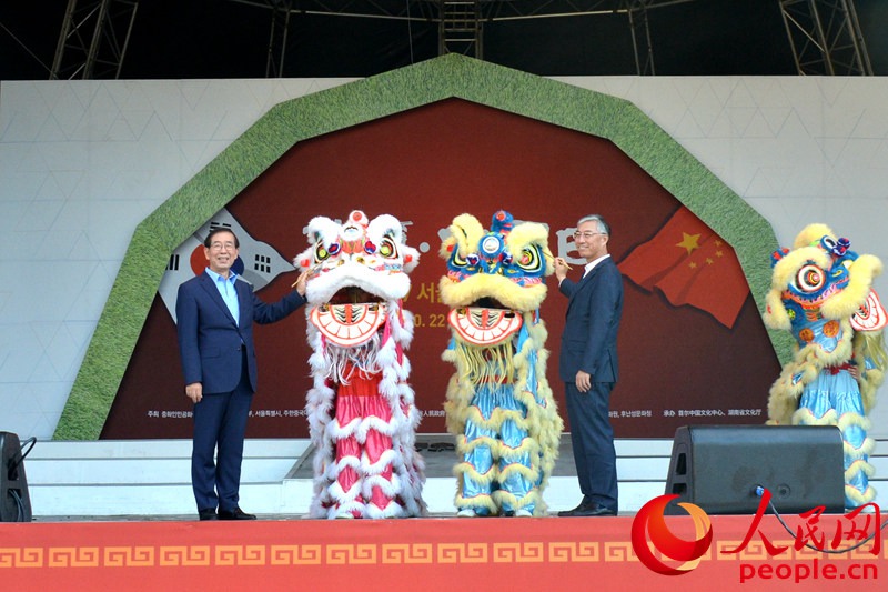 中国驻韩国大使邱国洪（右）与首尔市长朴元淳一同执笔为醒狮点睛。