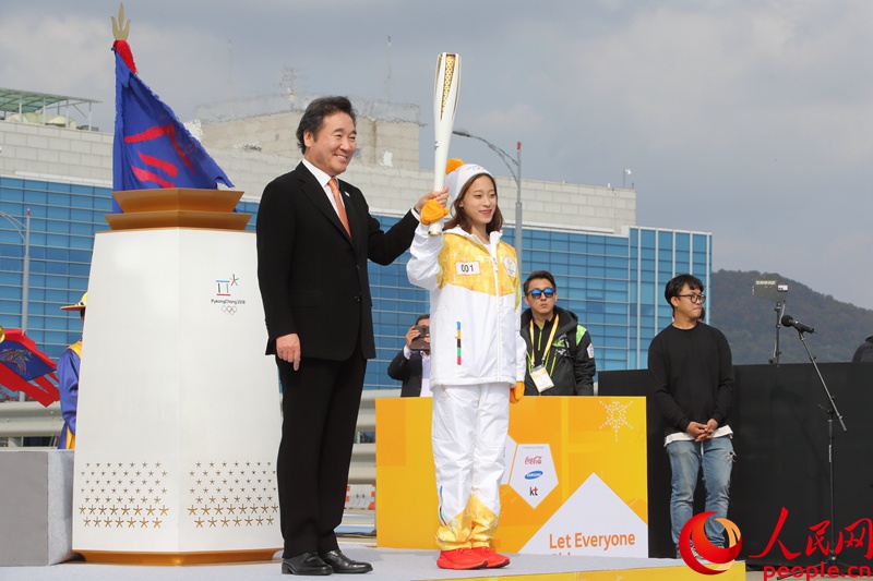 韓國國務總理李洛淵點燃火炬交給首名火炬手韓國花樣滑冰運動員柳英。